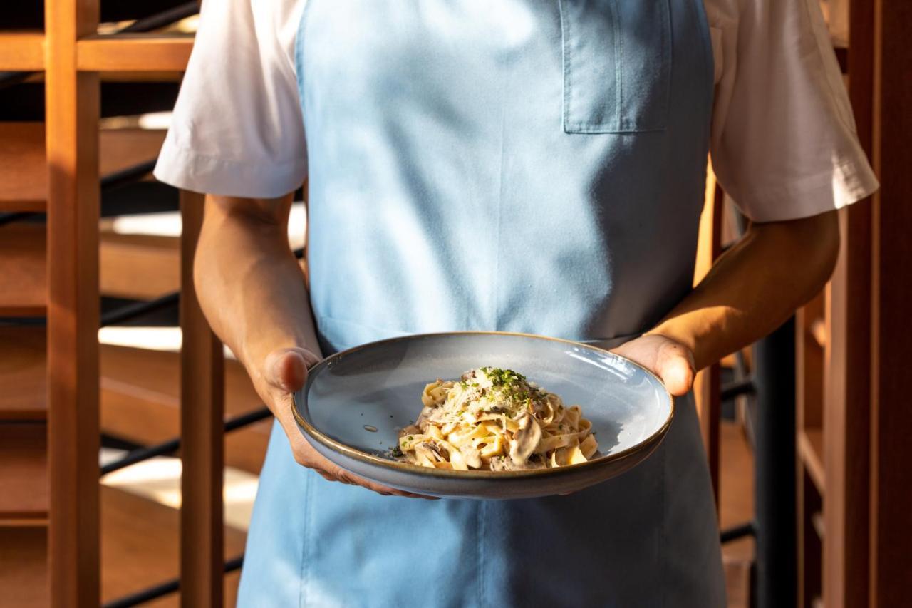 Outrigger Surin Beach Resort - SHA Extra Plus Exterior foto A server holding a plate of pasta