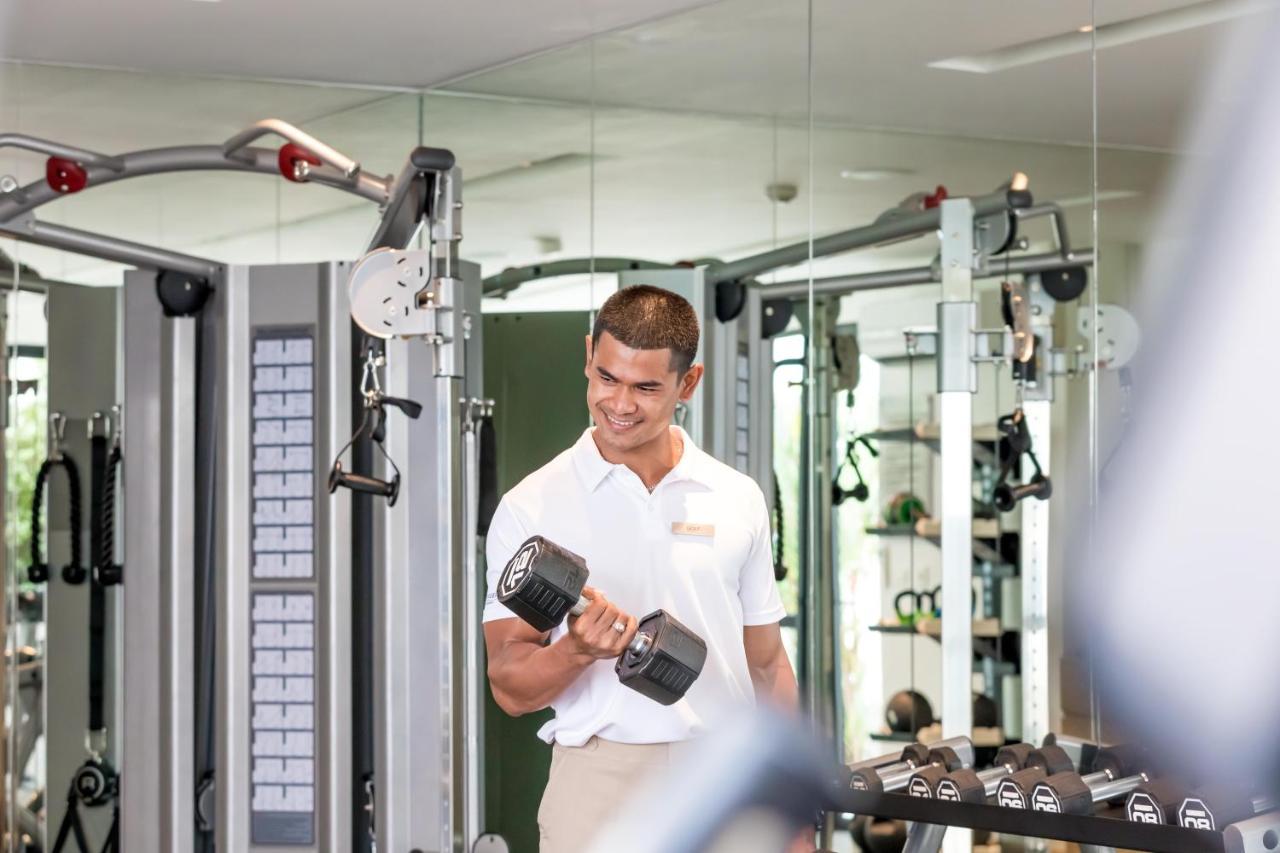 Outrigger Surin Beach Resort - SHA Extra Plus Exterior foto A man lifting a dumbbell